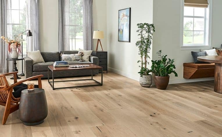 Living room with light oak hardwood flooring ideas by Reflex Builders featuring modern furniture, large windows, and natural light.